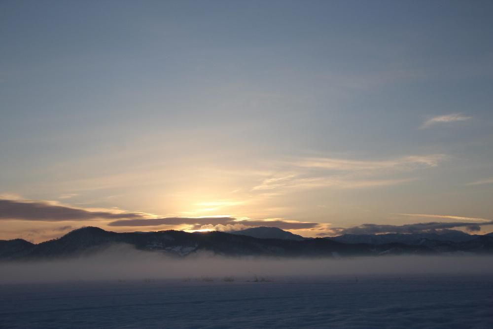 朝から眩しくなりそうに陽の光がさしこんでいます　朝日が昇る頃朝霧でしょうか山と地平線の間に立ち込めています　今年最後のお天気になるのでしょうか思わず写真を撮りました