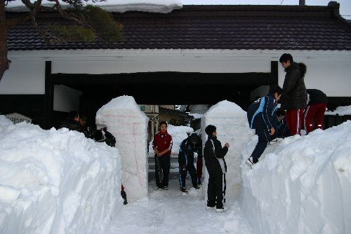 夕焼けの中で雪灯篭づくり
