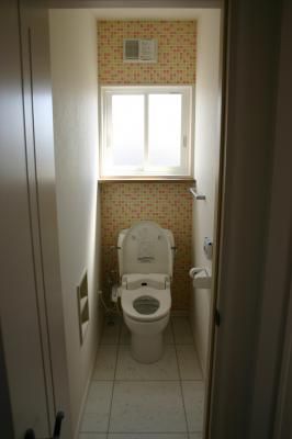 正面のアクセント壁紙がかわいらしいトイレスペース