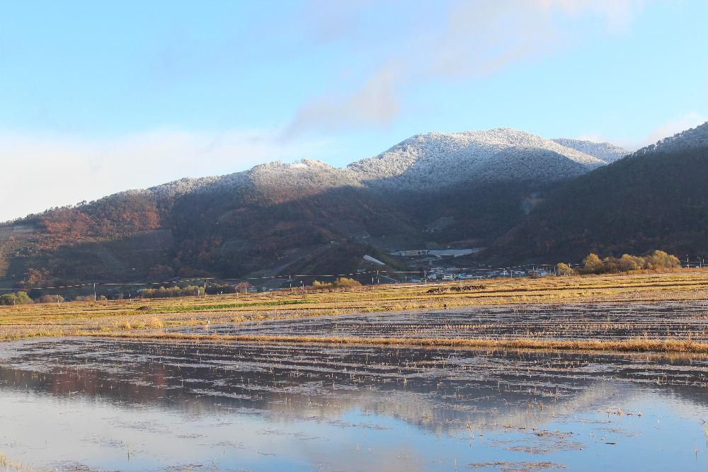 逆さ十分一山です　天候が落ち着かない中　晴れ間が見えてきたので十分一山の冠雪を撮りました　水の入った田んぼに十分一山が逆さに映し出されています　逆さ富士ならず逆さ十分一山です