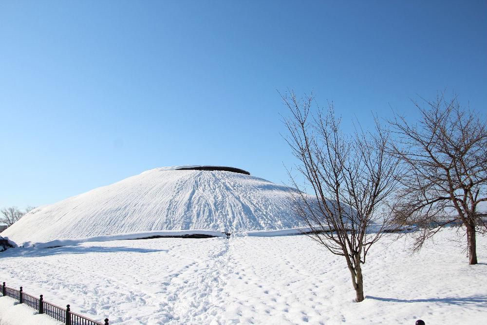 雪も一休みでしょうか　今朝は気温が低いものの雪がふっていません　今日の赤湯冬点描は稲荷森古墳です　古墳では子供たちのそり遊びの場所になっているのでしょうかそりの滑ったあとがみられました　てっぺんに立つと置賜盆地一円が見えます　