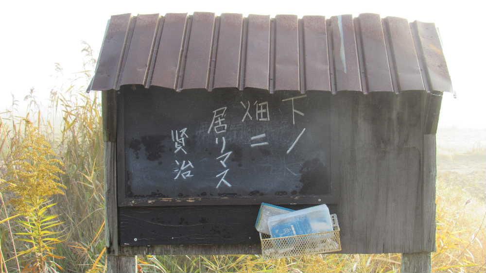 いたずら書きをしてしまいました　霧の中の田んぼの畔に用水路の連絡掲示板がありましたので「下ノ畑二居リマス　賢治」とチョークで書き込んみました　花巻市にある宮沢賢治の記念館を訪れたときに見てきたのを思い出し書き込みました　宮沢賢治の記念館の掲示板は宮沢賢治が家に不在の時に、彼に会いにきた人が迷わない為に玄関に 「下ノ畑ニ居リマス」 と書き残されているものです。宮沢賢治の優しさを感じさせるものの一つです　いたずら書きを消し忘れましたので早く消してこなければ