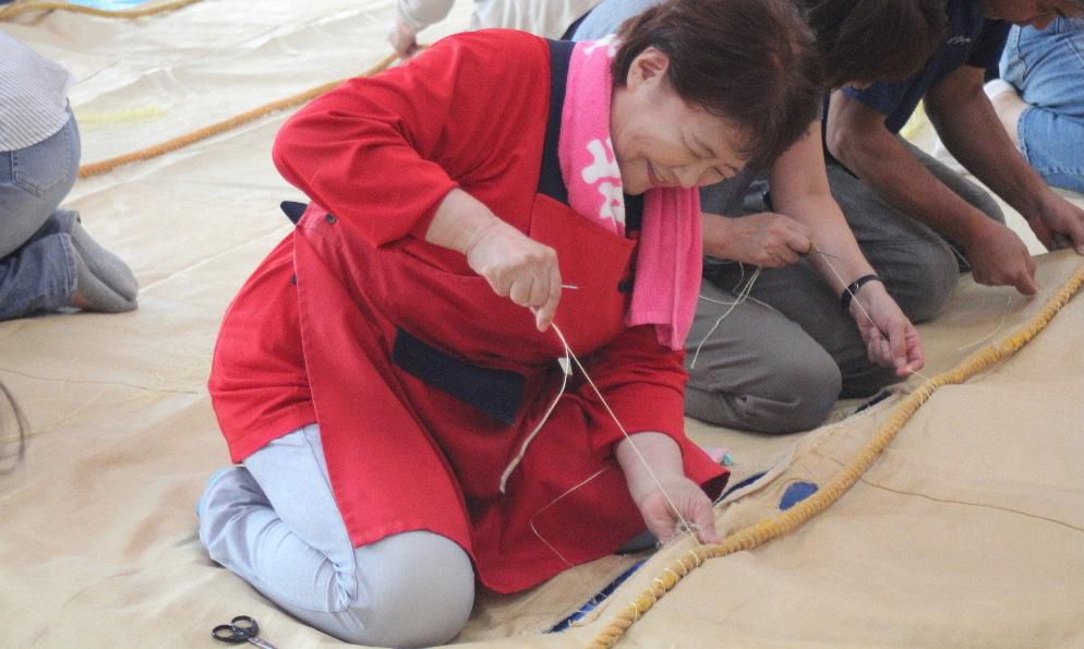 第49回の赤湯温泉ふるさと祭りが12、13日の2日間行われます この祭りの最後に行われる暴れ獅子と呼ばれる獅子舞は勇壮な男の祭りを感じさせてくれます この暴れ獅子で使われる獅子を載せた幕には太いロープが縫い付けられ数十人で引き合っても決して切れることのないもので 祭りを前に「幕縫い」が行われました 太い麻糸(今はビニール糸)で縫いつけていく作業ですが祭りを裏で支える大切な作業です